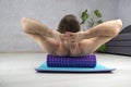 Man doing fascial exercise of back with foam roller. Man performing back exercise on myofascial roller at home Royalty Free Stock Photo