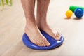 Man doing flatfoot correction gymnastic exercise balancing on massage cushion at home Royalty Free Stock Photo