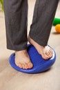 Man doing flatfoot correction gymnastic exercise balancing on massage cushion at home Royalty Free Stock Photo