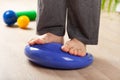 Man doing flatfoot correction gymnastic exercise balancing on massage cushion at home Royalty Free Stock Photo