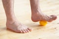 Man doing flatfoot correction gymnastic exercise using massage ball at home Royalty Free Stock Photo