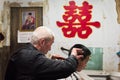 Man doing an haircut in an ancient village in China