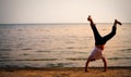 Man doing handstand on beach