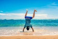 Man doing handstand on the beach Royalty Free Stock Photo