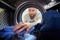 Man Doing Laundry Reaching Inside Washing Machine Royalty Free Stock Photo