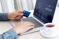 Man doing online shopping with credit card on laptop