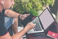 Man doing online shopping with credit card, laptop and luxury snakeskin python wallet. Man online shopping concept. Royalty Free Stock Photo