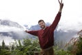 Man doing the peace hand sign at the top of a mountain