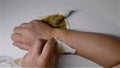 Man doing physiotherapy on hurted hand with Chinese medicine nearby