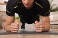 Man doing plank exercise on floor at home, closeup Royalty Free Stock Photo