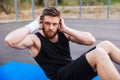 Man doing press exersices on the blue fitness mat outdoors