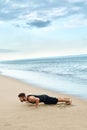 Man Doing Push Up Exercise On Beach. Body Exercising Concept Royalty Free Stock Photo