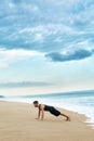 Man Doing Push Up Exercise On Beach. Body Exercising Concept Royalty Free Stock Photo