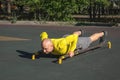 Man doing push-ups on parallel bars while exercising at an outdoor sports ground on a sunny summer day. Royalty Free Stock Photo