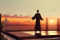 Man doing qigong tai chi exercise or reiki wearing kimono at sunrise on the roof with cityscape view. Qigong male Master