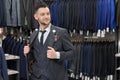 Man doing shopping in boutique, trying on grey stylish suit. Royalty Free Stock Photo