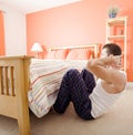 Man Doing Sit-Ups in Bedroom Royalty Free Stock Photo