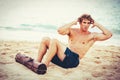 Man Doing Sit-Ups Outdoors on the Beach Royalty Free Stock Photo