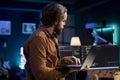 Programmer reading source code on laptop, crosschecking with computer monitors Royalty Free Stock Photo