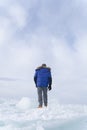 A man doing solo outdoor activity, enjoying time alone in nature, walking on frozen lake in winter Royalty Free Stock Photo