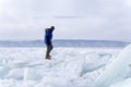 A man doing solo outdoor activity, enjoying time alone in nature, walking on frozen lake in winter Royalty Free Stock Photo