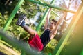 Man doing stomach workouts on horizontal bar outdoors