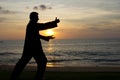 Man doing taiji at sunset at the beach