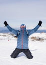 Man doing victory sign after peak summit trekking achievement in snow mountain on winter landscape