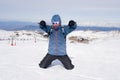 Man doing victory sign after peak summit trekking achievement in snow mountain on winter landscape