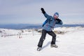 Man doing victory sign after peak summit trekking achievement in snow mountain on winter landscape