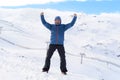 Man doing victory sign after peak summit trekking achievement in snow mountain on winter landscape