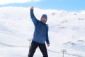 Man doing victory sign after peak summit trekking achievement in snow mountain on winter landscape