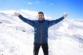 Man doing victory sign after peak summit trekking achievement in snow mountain on winter landscape