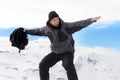 Man doing victory sign after peak summit trekking achievement in snow mountain on winter landscape