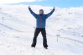 Man doing victory sign after peak summit trekking achievement in snow mountain on winter landscape