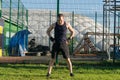 Man doing warm-up before strength training outdoors on green grass Royalty Free Stock Photo
