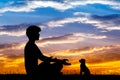 Man doing yoga with dog at sunset Royalty Free Stock Photo