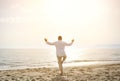 Man doing yoga exercises on the beach - healthy lifestyle concept