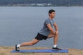 Man doing yoga outdoor. Young man practicing yoga fitness exercise outdoor at beautiful sea. Meditation and relaxation Royalty Free Stock Photo