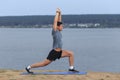 Man doing yoga outdoor. Young man practicing yoga fitness exercise outdoor at beautiful sea. Royalty Free Stock Photo