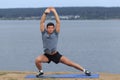 Man doing yoga outdoor. Young man practicing yoga fitness exercise outdoor at beautiful sea. Meditation and relaxation. Royalty Free Stock Photo