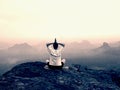 Man is doing Yoga pose on the rocks peak within misty morning Royalty Free Stock Photo