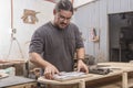 A man double checking his working drawings of a table at his furniture workshop Royalty Free Stock Photo