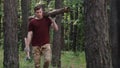 A man drags a felled log through the forest