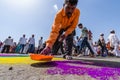 A man drawing rangoli on the road to welcome palkhi