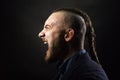 Man with dreadlocks screams in a rage, looks like a viking, Iroquois haircut Royalty Free Stock Photo