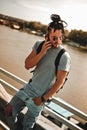 Man with dreadlocks talking angry on the phone by the river