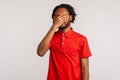 Man with dreadlocks wearing red casual style T-shirt, closing eyes with hand, dont want to see that Royalty Free Stock Photo