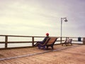 Man dreaming sitting on a wooden pier near the water Royalty Free Stock Photo