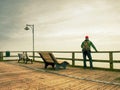 Man dreaming sitting on a wooden pier near the water Royalty Free Stock Photo